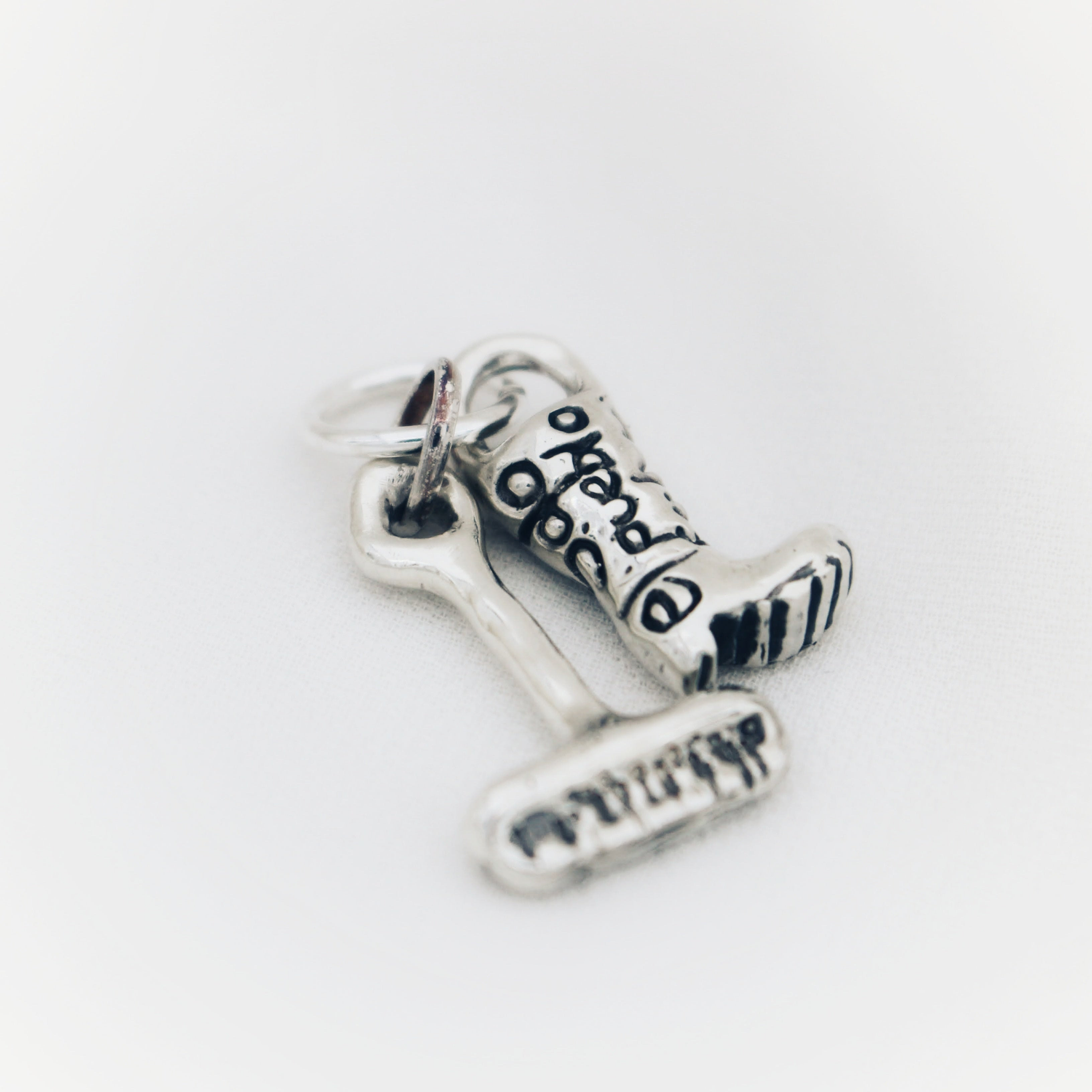 Solidarity Pendants Collection silver rain boot pendant engraved with the message Solo el pueblo salva al pueblo Desde Valencia para Valencia