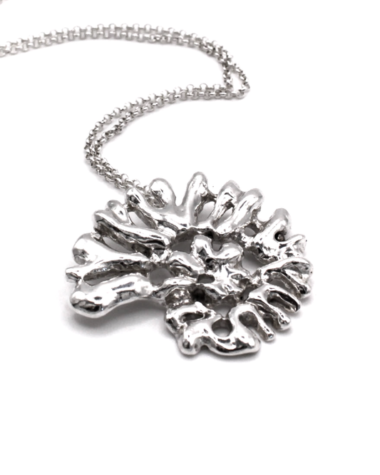 A silver necklace featuring an organic, coral-like textured pendant on a delicate link chain, photographed against a clean white background.