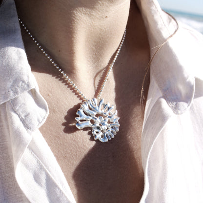 Close-up of sculptural spiral shell pendant necklace handcrafted in recycled sterling silver