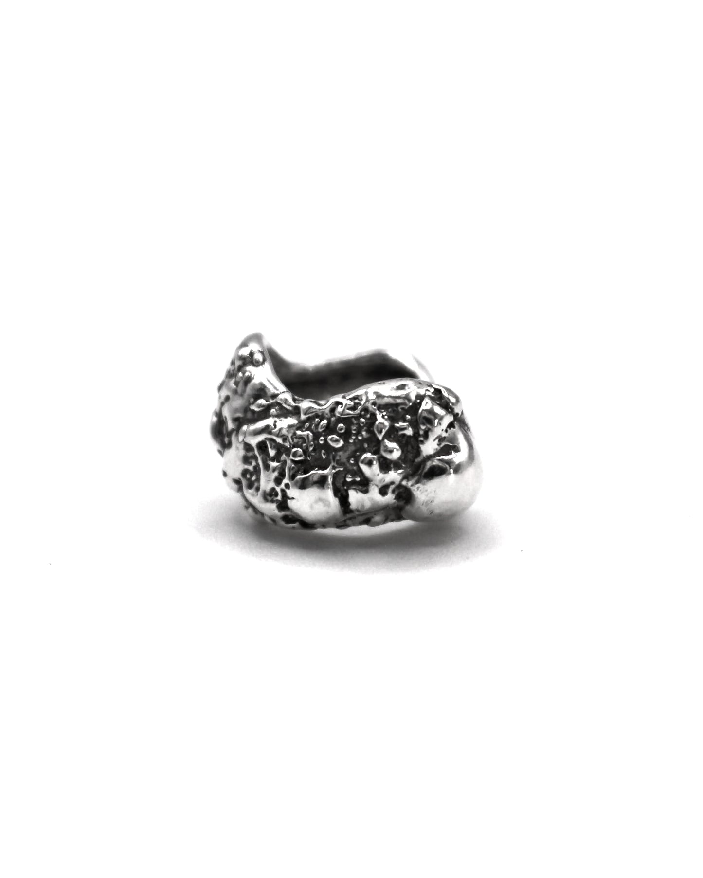 Sterling silver ear cuff with organic textured surface inspired by Mediterranean sea-worn stones on a white background.