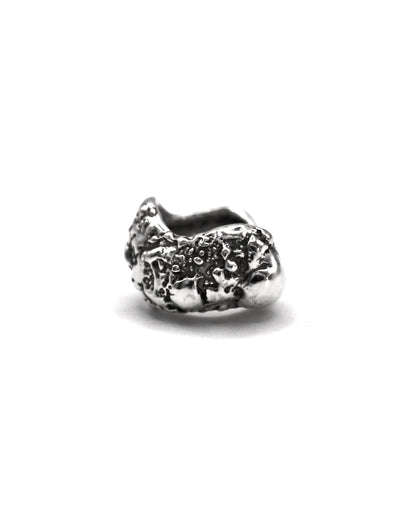 Sterling silver ear cuff with organic textured surface inspired by Mediterranean sea-worn stones on a white background.