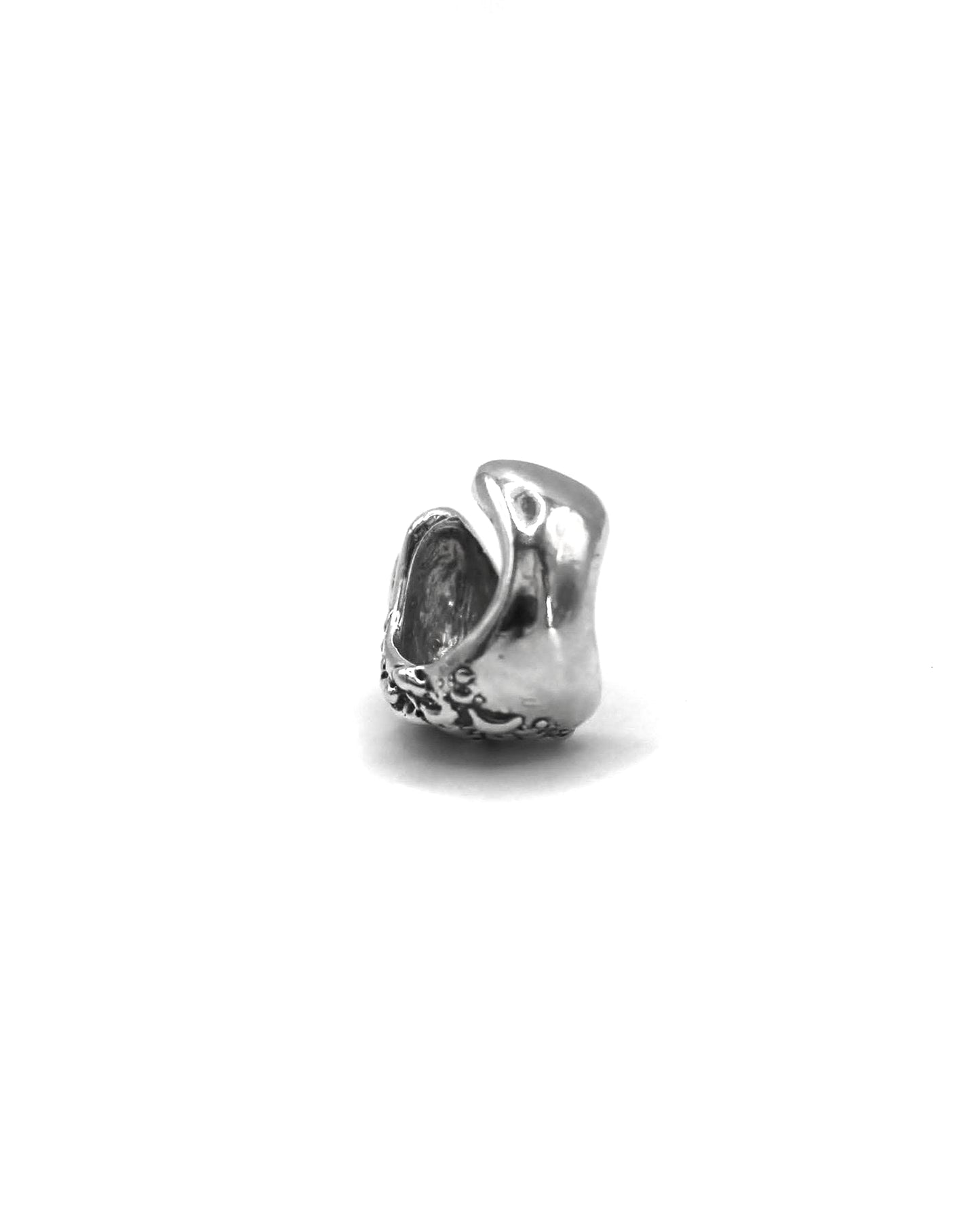 Side view of the Piedra Sorra sterling silver ear cuff showing its sculptural handmade texture on a white background.