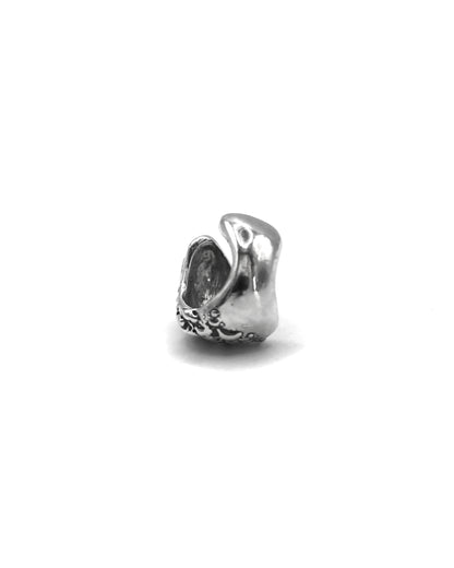 Side view of the Piedra Sorra sterling silver ear cuff showing its sculptural handmade texture on a white background.
