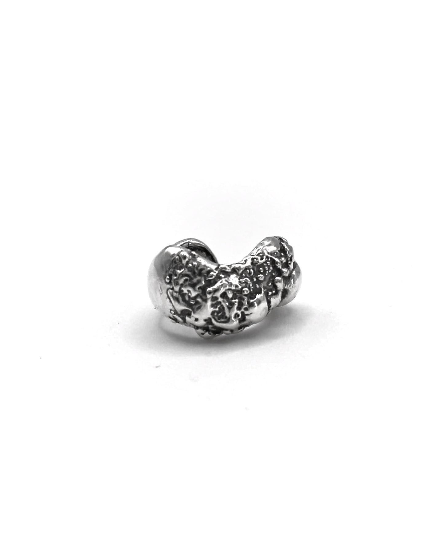 Detailed view of the handcrafted sterling silver Piedra Sorra ear cuff with sculptural surface inspired by sea-shaped stones.
