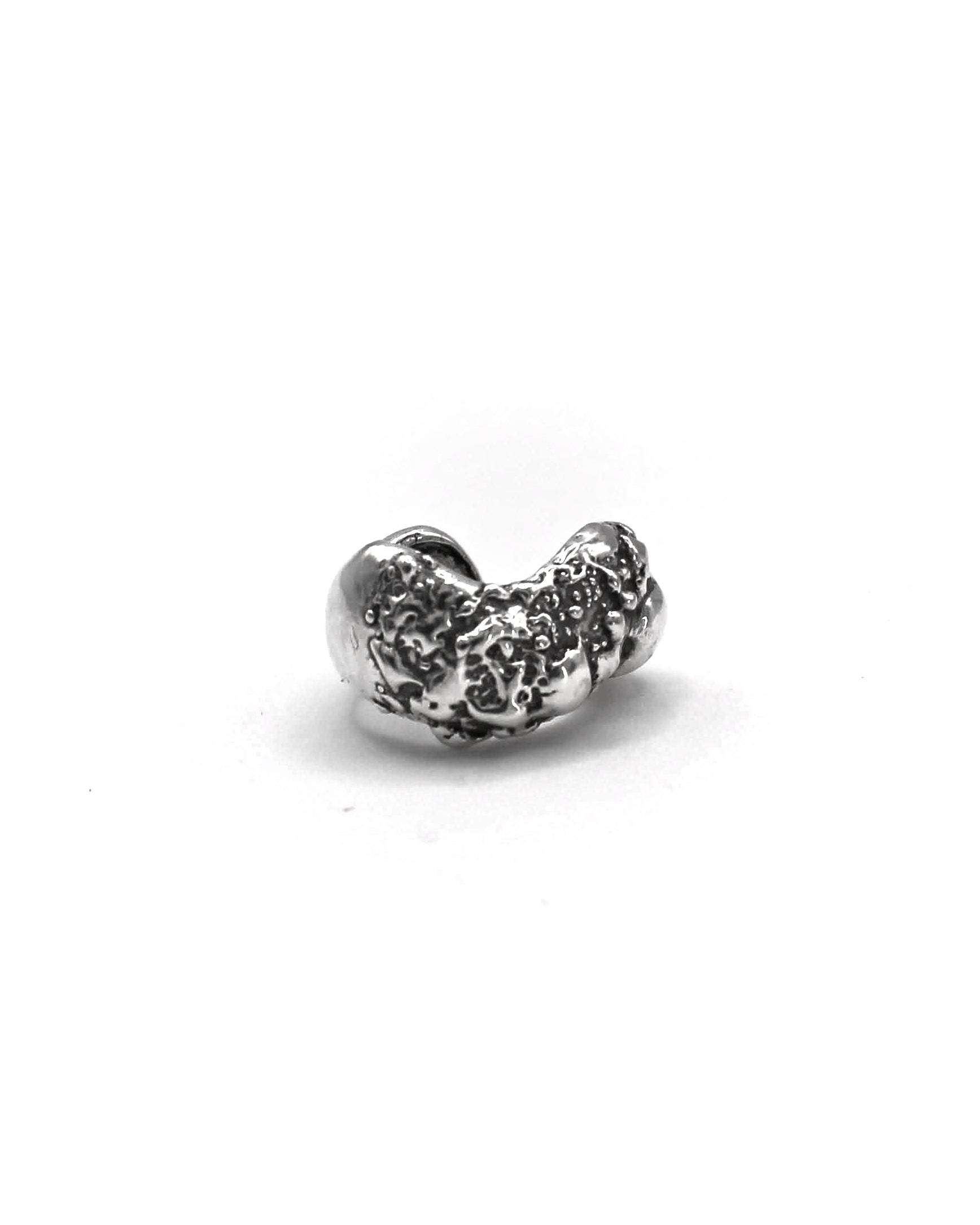 Detailed view of the handcrafted sterling silver Piedra Sorra ear cuff with sculptural surface inspired by sea-shaped stones.