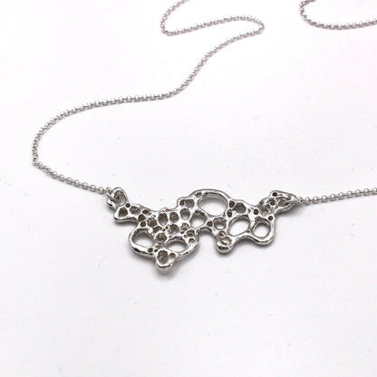 Mediterranean inspired Raíz Seafoam Pendant in silver. Symbolic jewelry capturing change, resilience, and the beauty of the present moment.