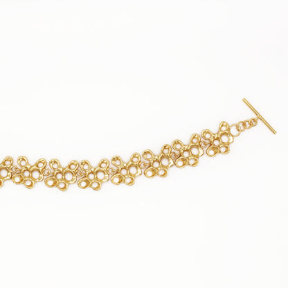 Raíz bracelet handcrafted in sterling silver with a gold-plated finish. Mediterranean-inspired jewelry formed of nine organic-shaped segments with a stylish toggle clasp. A bold yet elegant sustainable bracelet for nature and contemporary jewelry lovers, crafted by Naturalesa.