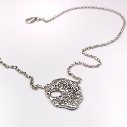Rastro del Mar silver pendant from Piedra Collection, inspired by Mediterranean hag stones.
Colgante Rastro del Mar de plata de la Colección Piedra, inspirado en piedras agujereadas mediterráneas.