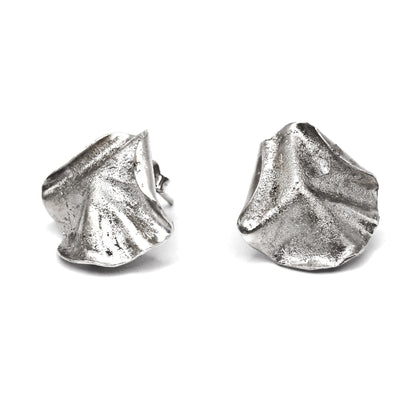 Sculptural folded silver earrings, handcrafted in recycled sterling silver using the lost wax casting technique. Mediterranean-inspired jewelry with organic, wave-like forms and a unique fused silver dust texture. Elegant and sustainable statement earrings for nature and contemporary jewelry lovers, crafted by Naturalesa.