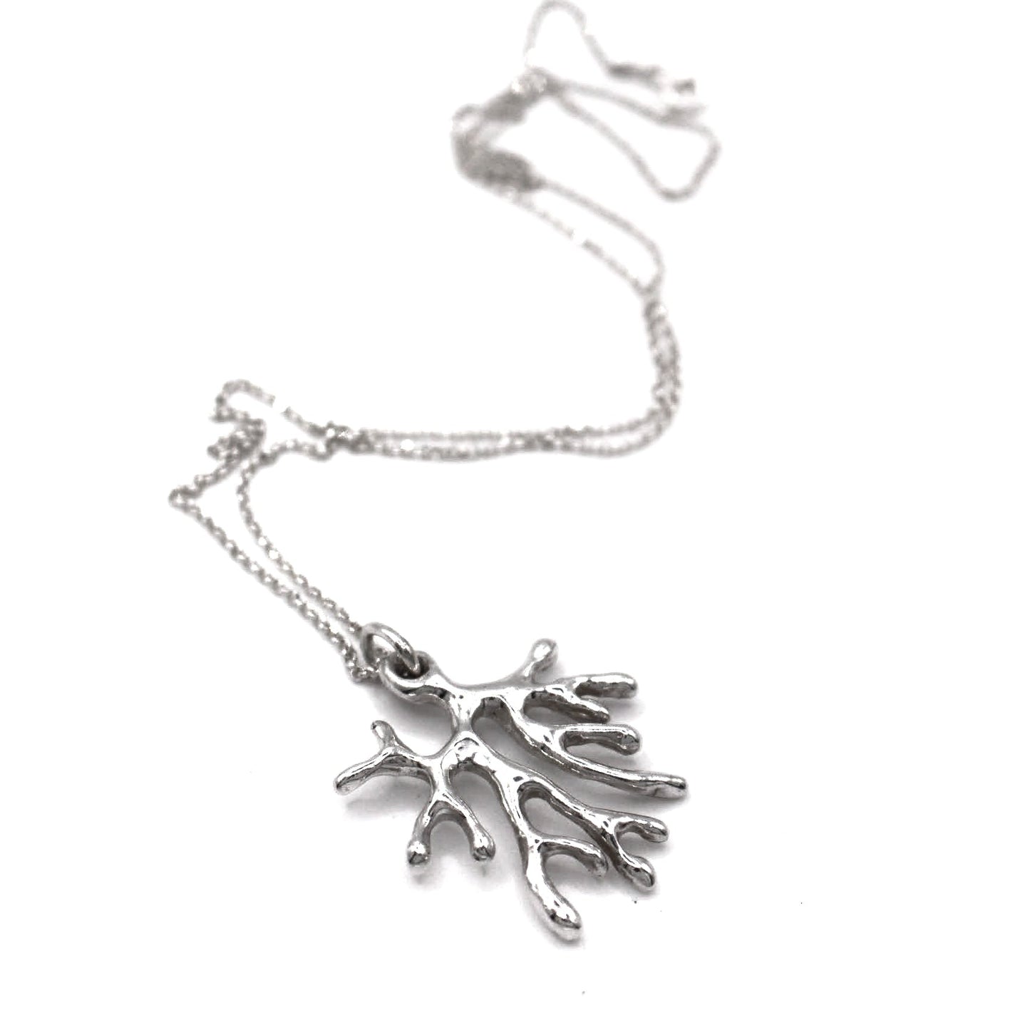 Silver coral-shaped pendant on a chain against a white background