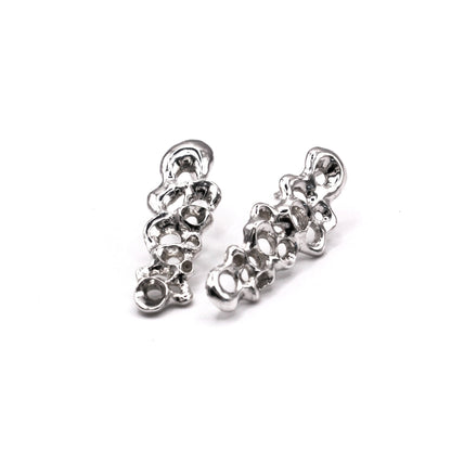 Pair of silver earrings on a white background. Pendientes largos Raíz en plata reciclada 925, pendientes asimétricos inspirados en bellotas del mar de Naturalesa Jewelry.