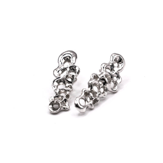 Pair of silver earrings on a white background. Pendientes largos Raíz en plata reciclada 925, pendientes asimétricos inspirados en bellotas del mar de Naturalesa Jewelry.
